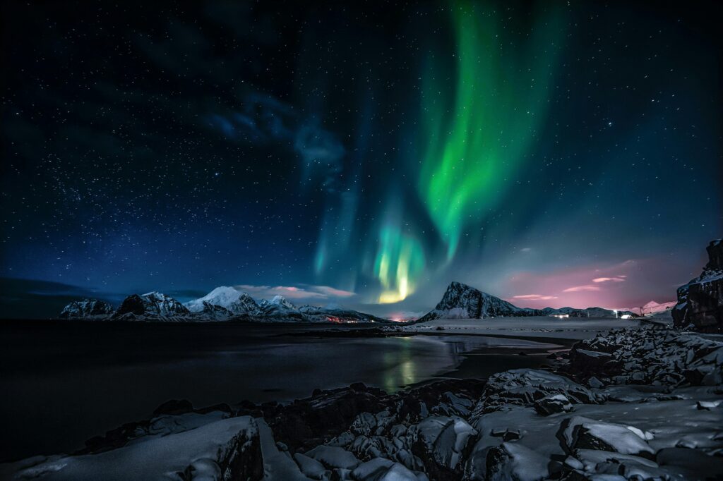 Breathtaking view of the Northern Lights illuminating the snowy landscape of Nordland, Norway.