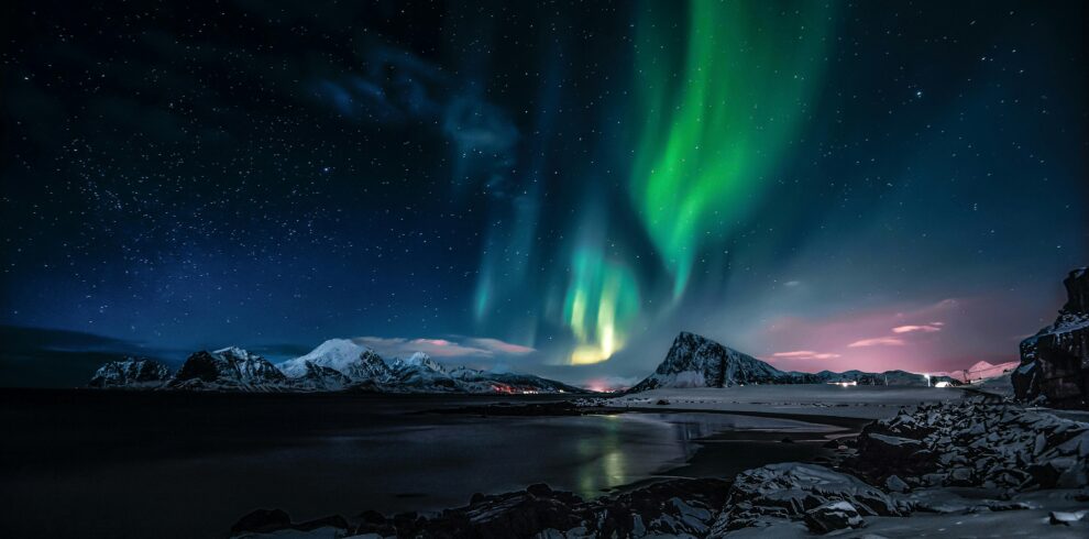 Breathtaking view of the Northern Lights illuminating the snowy landscape of Nordland, Norway.